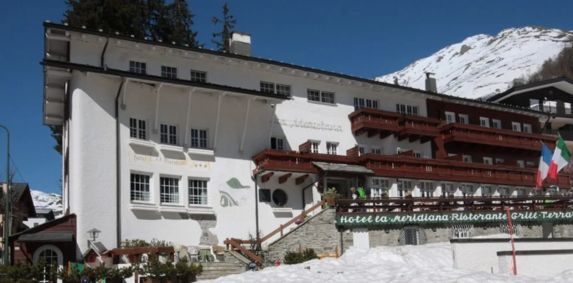 La facciata della Meridiana tra i tetti innevati e le cime di Madesimo
