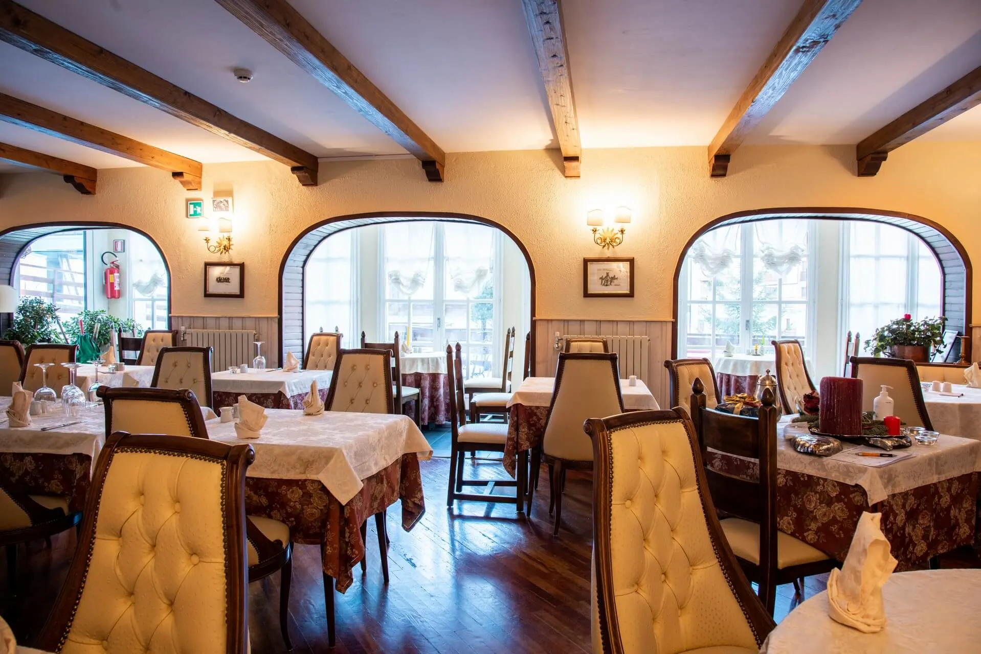 La sala del Ristorante 1945, con arredi in legno e veranda luminosa